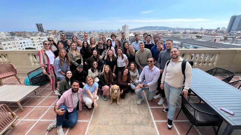 A group of AirDNA employees pose together outside