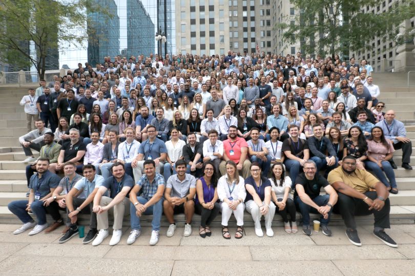 The entire Tegus team posing outdoors on a large granite staircase in Chicago