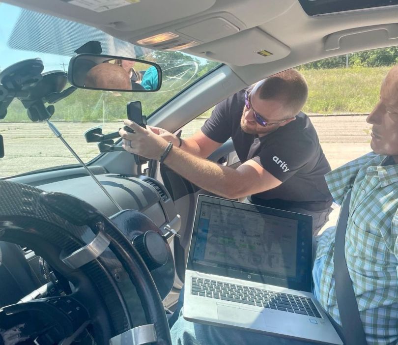 Arity team member works on car crash test dummy and equipment