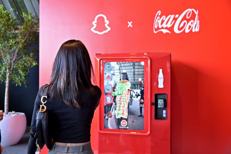  Photo of attendee using the AR-powered Coca-Cola vending machine