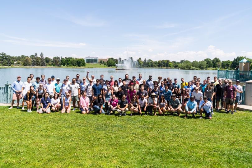 Large group photo in front of lake at Q3 2022 Ibotta picnic