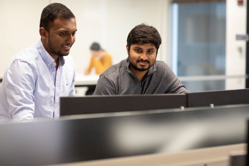 Candid photo of two OCC colleagues looking at something together, smiling