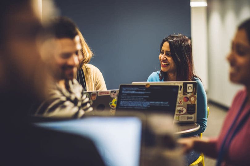 A woman smiles toward her colleagues