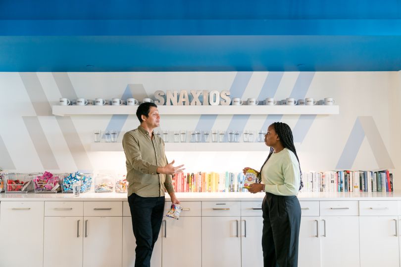 two axios team members converse in the axios office