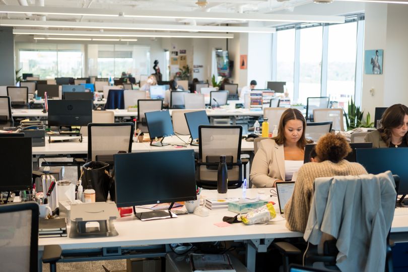 axios team members sit at a computer in the axios office