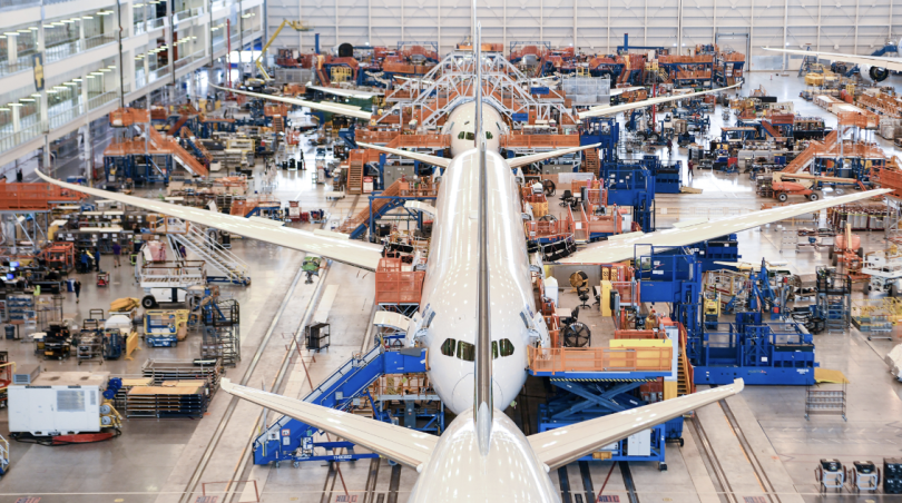 Boeing airplanes lined up in a row receiving maintenance work inside a hangar
