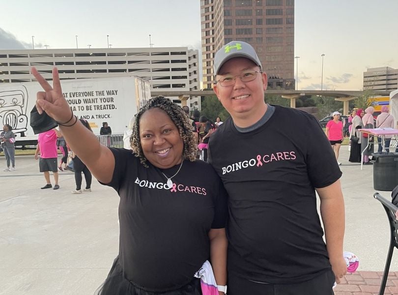 A woman holds up a peace sign next to a man