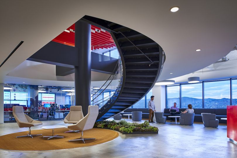 A black spiral staircase surrounded by windows