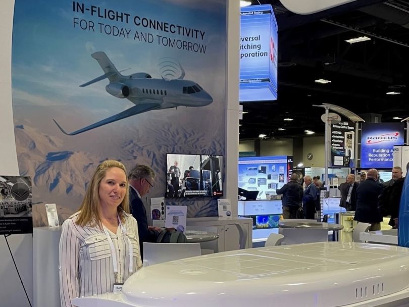 Photo of Emily McAnally at a Ball Aerospace booth at an expo