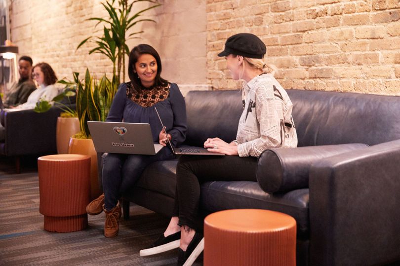 Bounteous team members having a team huddle looking at a laptop