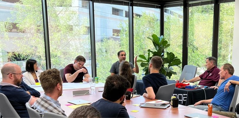 Brinqa team members sitting around a table