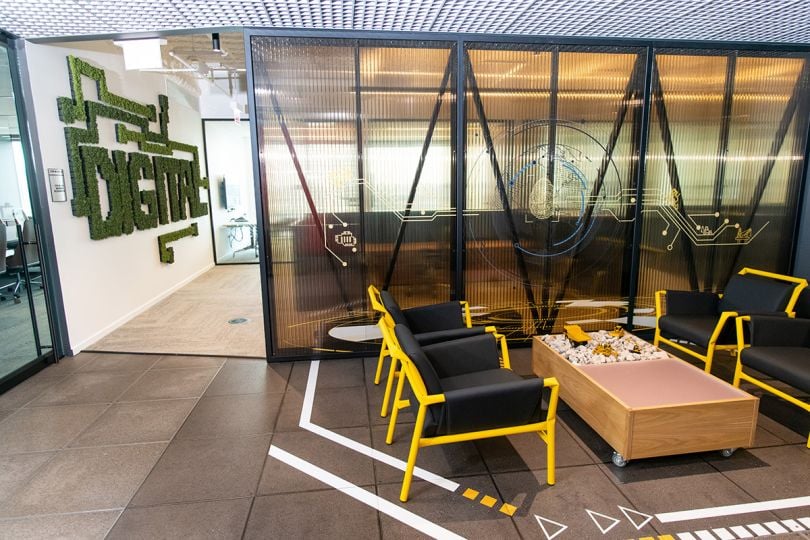 Sitting area in Cat Digital office with digital spelled out on the wall in plants