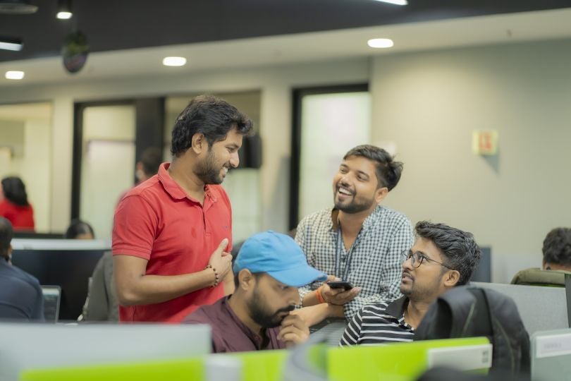 Candid photo of Q2 India employees working together, smiling.