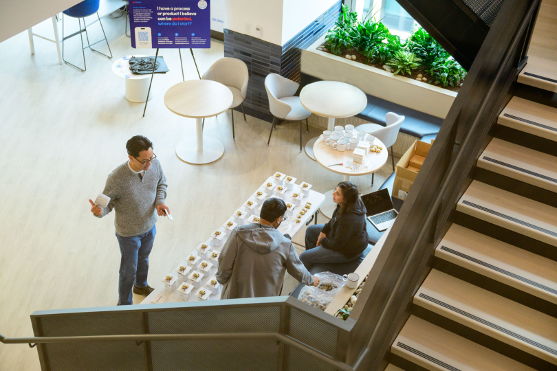 CarGurus employees are seen working below from a stairwell by a few white desks and chairs
