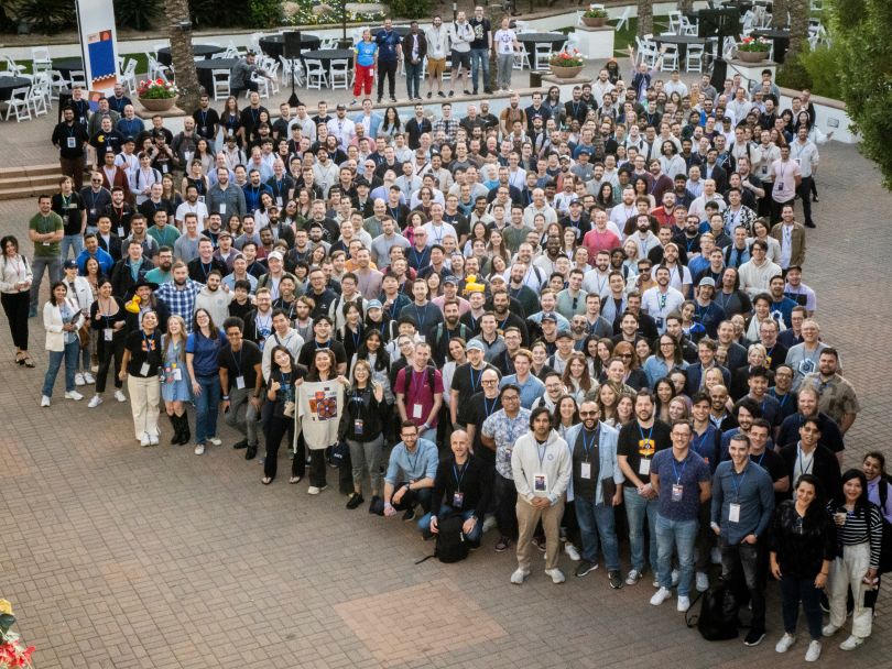 Chainlink Labs team members pose for a large group photo in an outdoor setting.