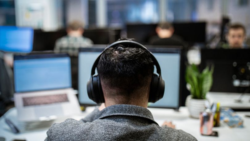 Claim representative wearing a phone headset looking at a monitor