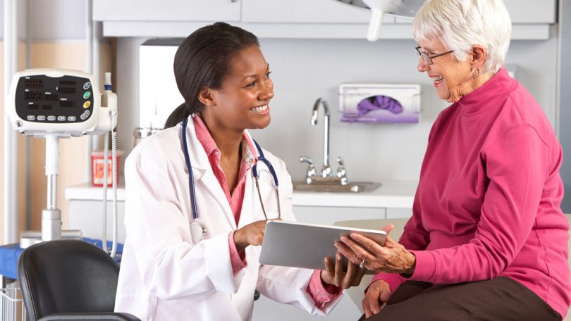 Doctor with a digital tablet talking with a patient