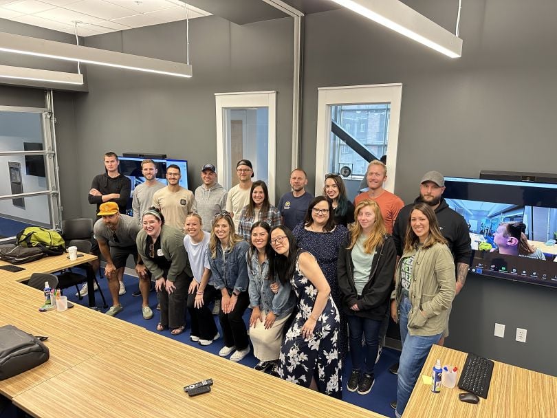 CompanyCam team members posing for a large group photo in their office.