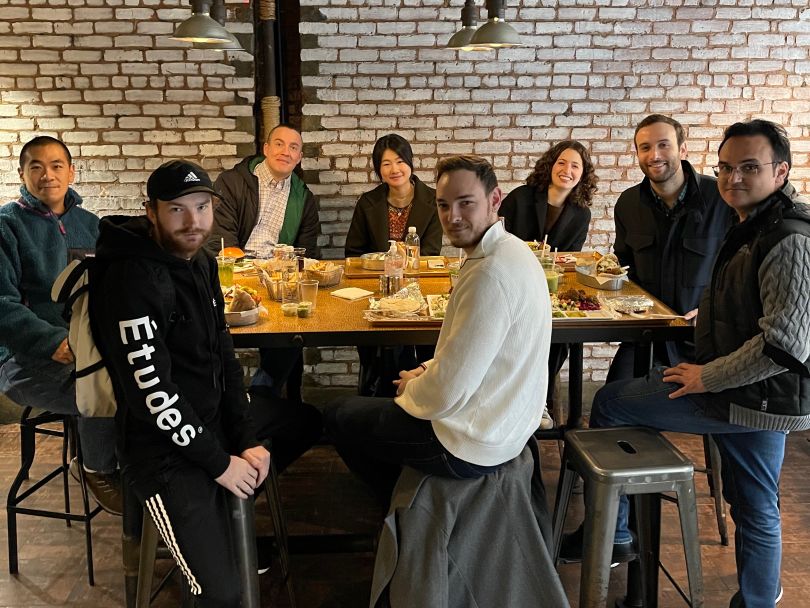  Group photo of Nibble Health team members around a table at a restaurant