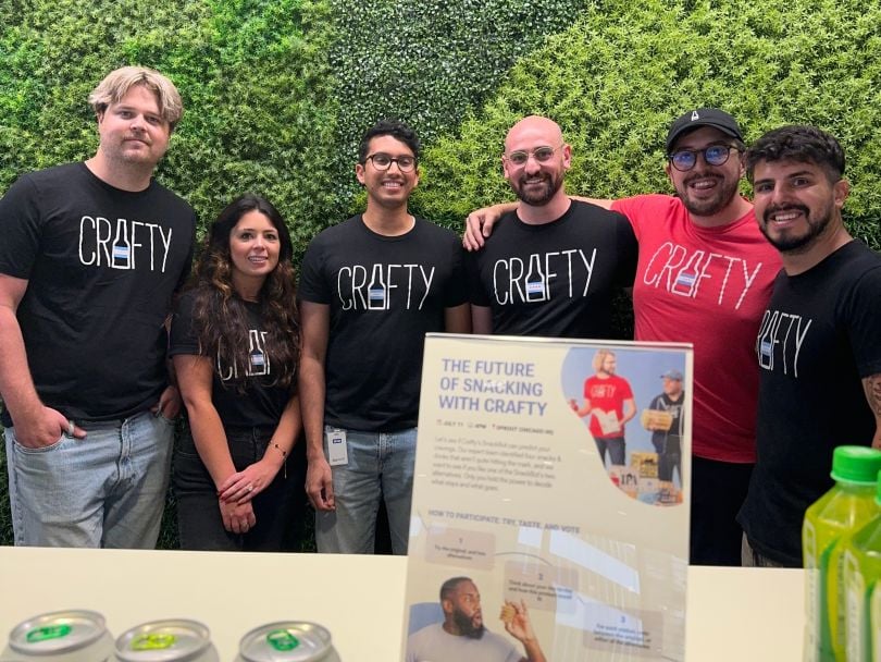 Crafty team members wearing company-branded t-shirts, posing for group photo at promotional booth