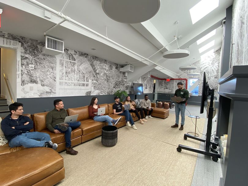 Current team members sitting on a couch in the office having a meeting