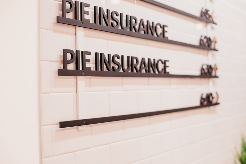 two stylized floor signs at Pie's DC office with underlines, both saying Pie Insurance