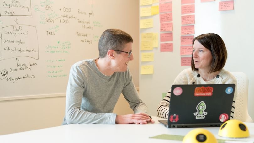 Two Redgate employees discuss a project in a conference room.