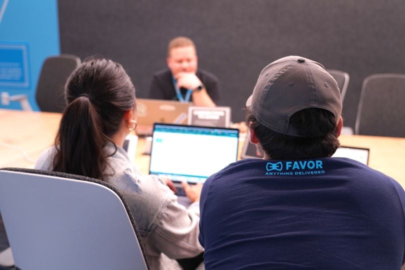 Photo taken from behind two Favor team members looking at a colleague across the table