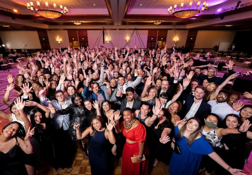 Large group photo taken from above in ballroom, formal attire