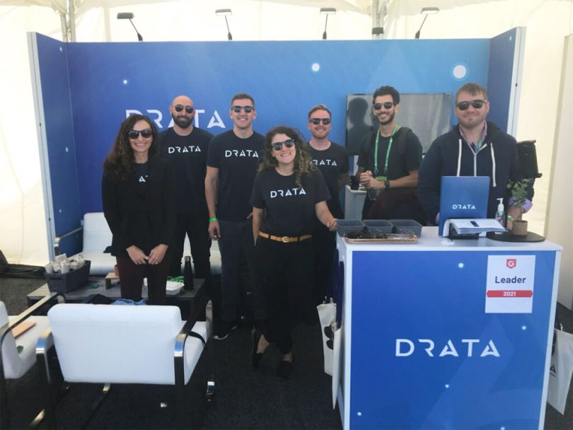 Team members at the Drata booth at a tech industry event