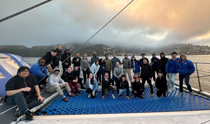 Group photo of Dropbox engineering team members on a boat dock in front of a body fo water.