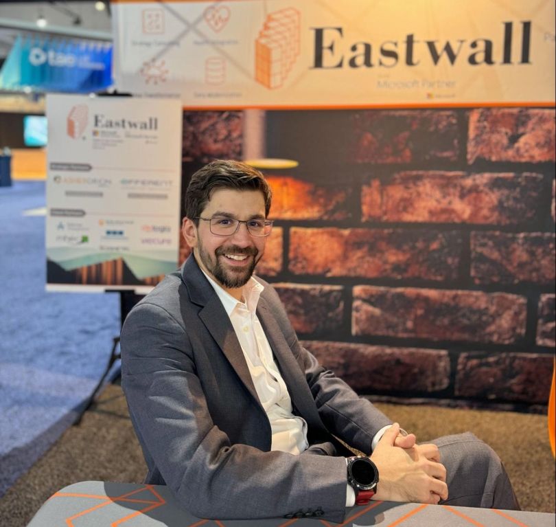  Eastwall Co-Founder and CEO Glenn Mate sits at an Eastwall booth at a conference.