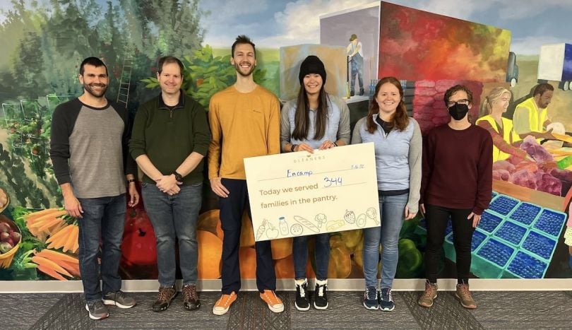 Encampers pose with a sign during a volunteer outing