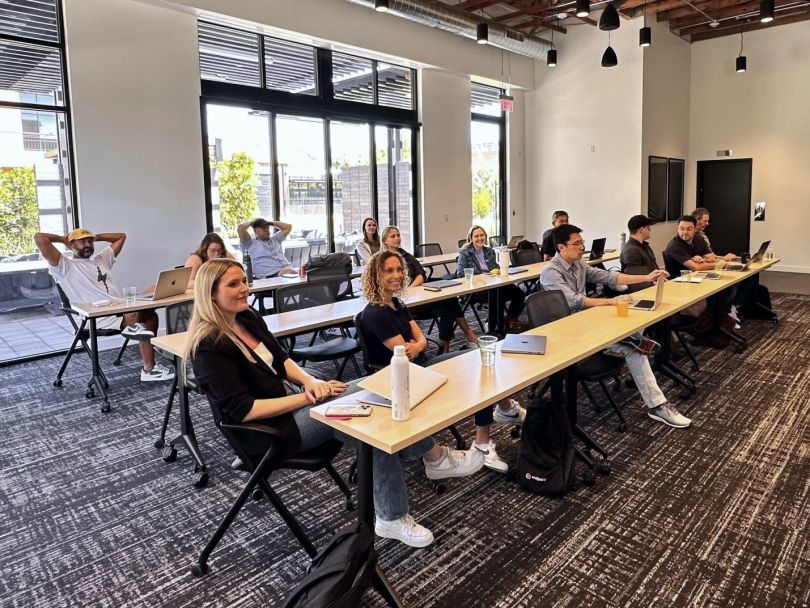 Endpoint team sitting at long desks in a conference room. 