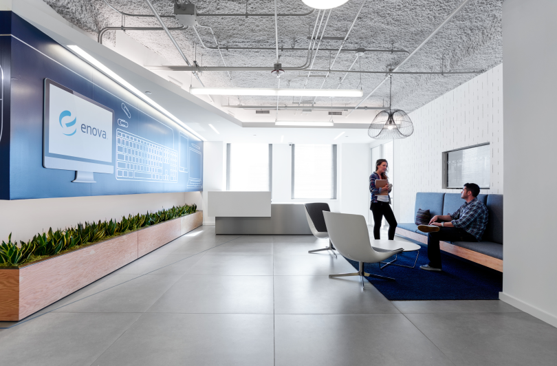 Two Enova team members chat together in a lounge space in the company’s office