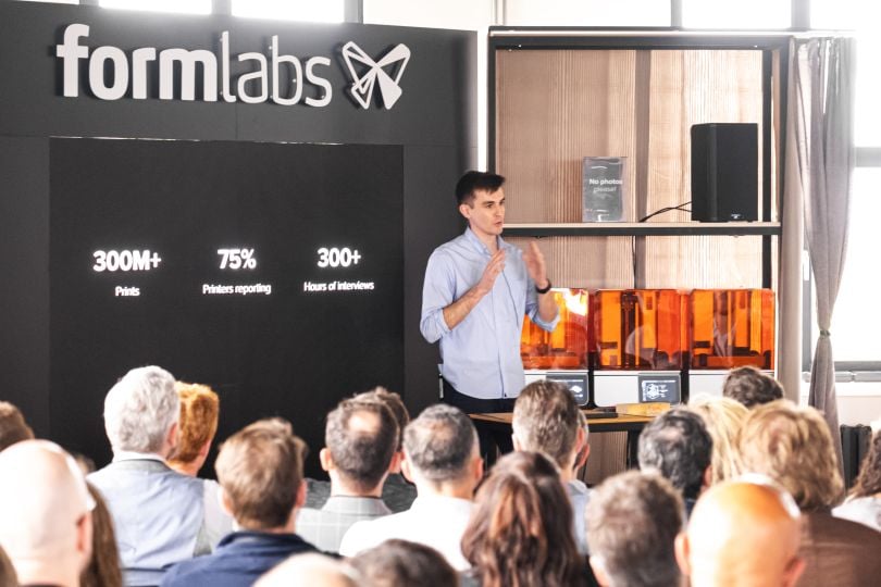 Kyle McNulty stands in front of a seated audience presenting the Form 4, Formlabs’ newest 3D printer.