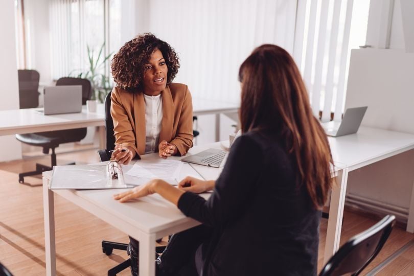 Image of a woman advising another woman sitting across from her 