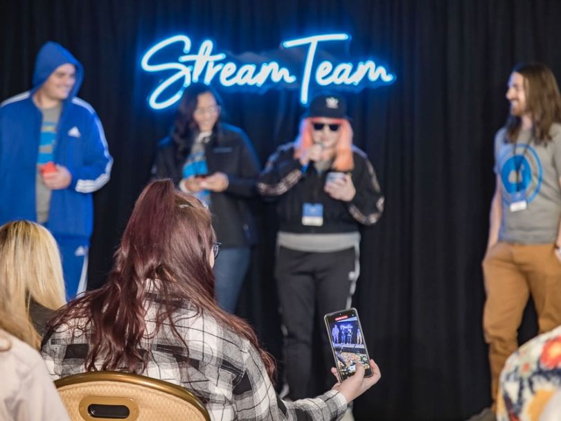 FluentStream employees on stage being photographed by another team member. 