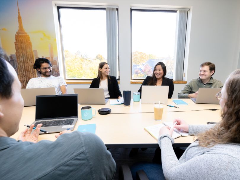 Galatea employees work around a conference room table