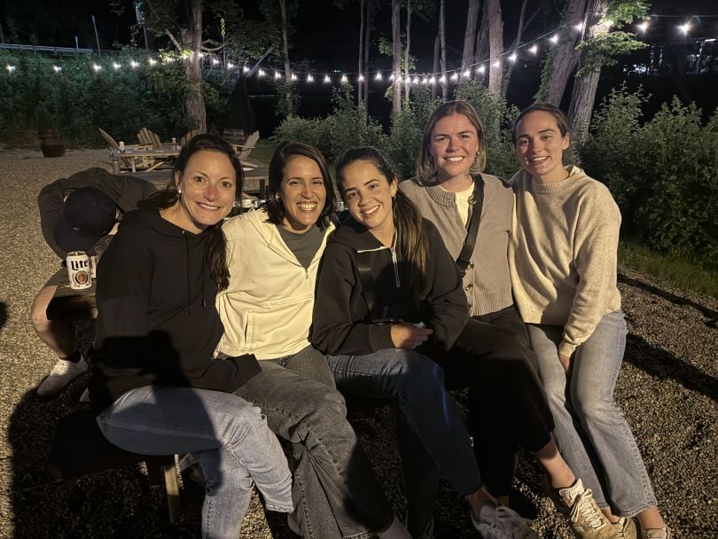 Gynger team members smiling and posing for group photo on outdoor patio during our latest offsite event.