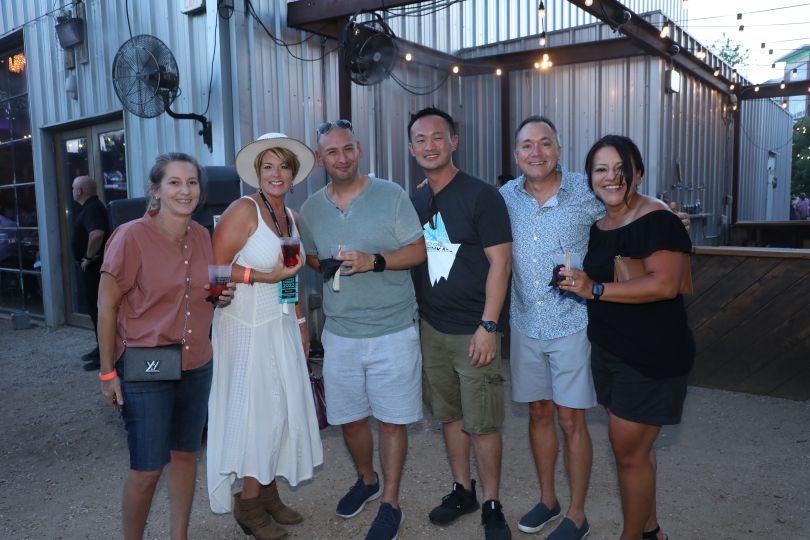 six huntress employees outdoors holding drinks