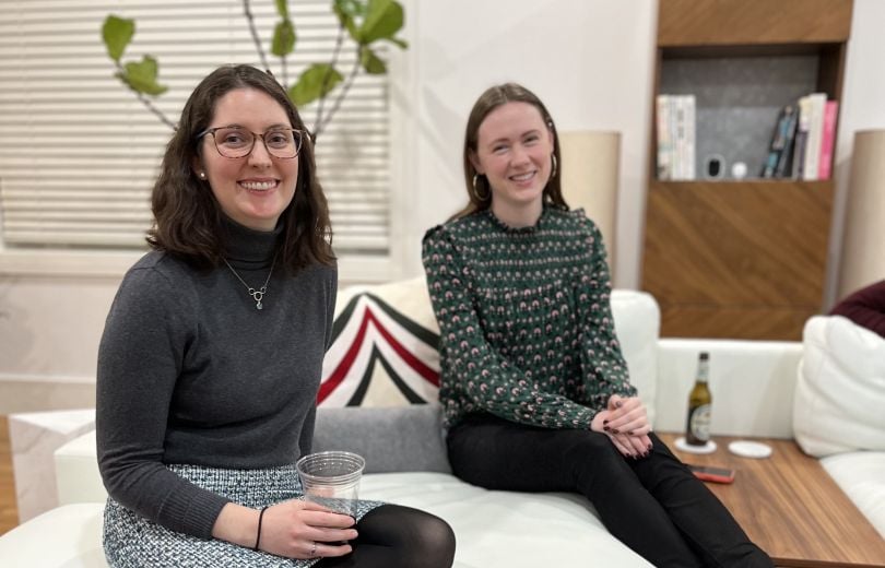 Two SmarterTravel team members sitting together on a couch.