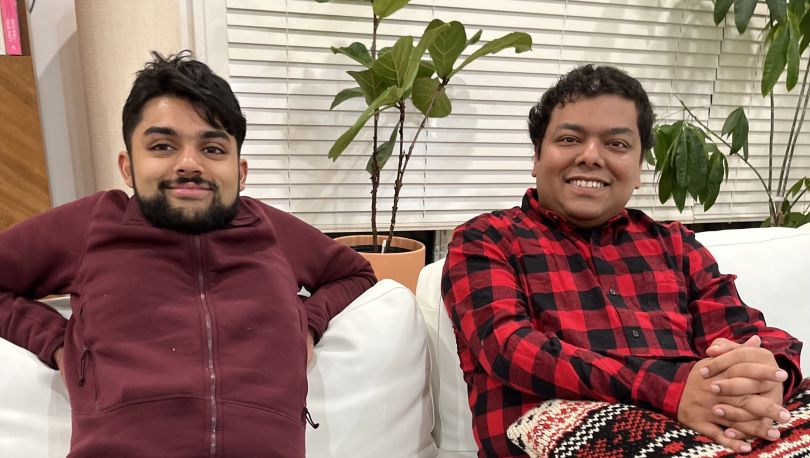 Two SmarterTravel team members sitting together on a couch.