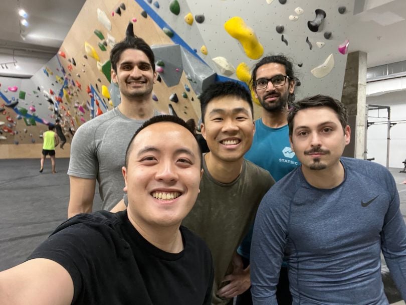 Andy Chen taking a selfie with four team members in rock climbing center