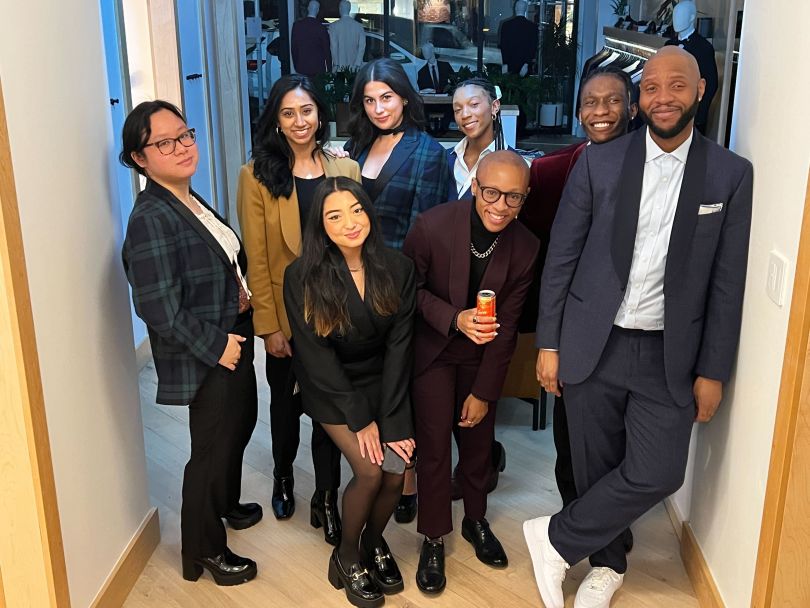 Members of The Black Tux's team pose in the office in formalwear 