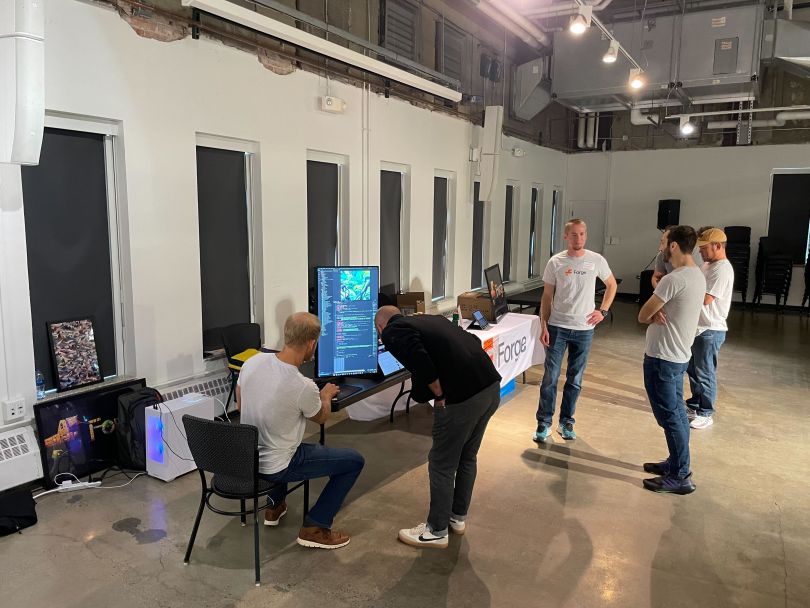 Tech team members gather around a table at a work event. 