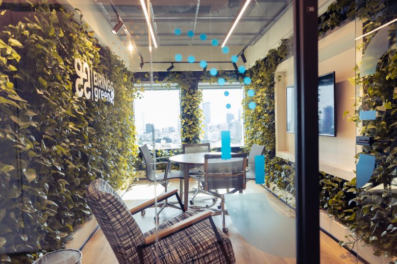  Photo of a Bringg conference room surrounded by green plant walls 