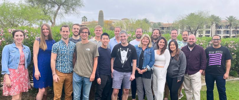 company photo with trees and city skyline in the background