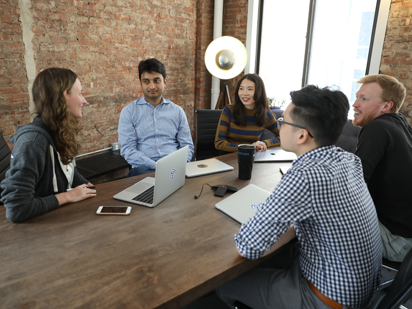 Bluecore team members having a meeting seated around a table