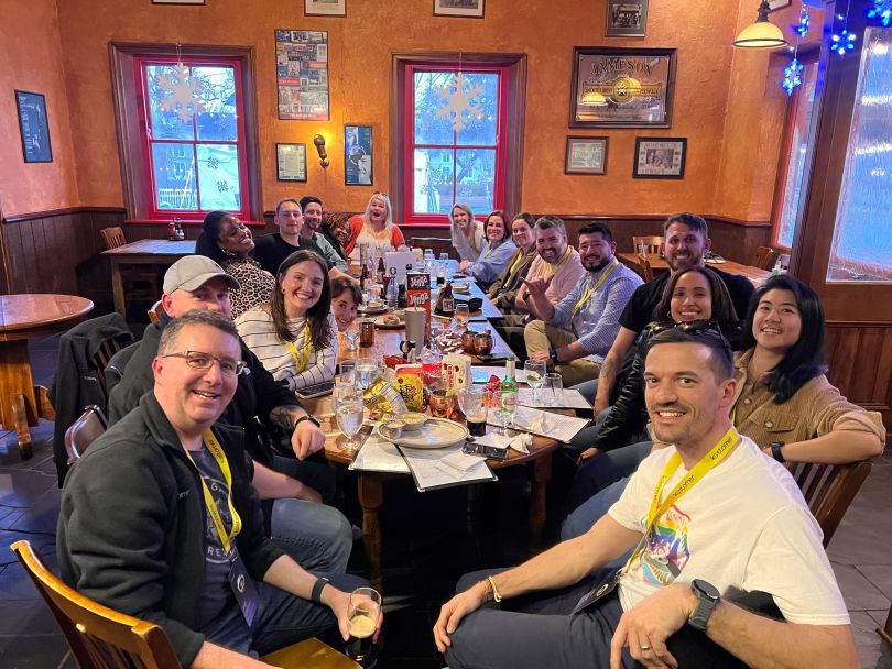 Kustomer team members posing for a photo while eating dinner together at a restaurant